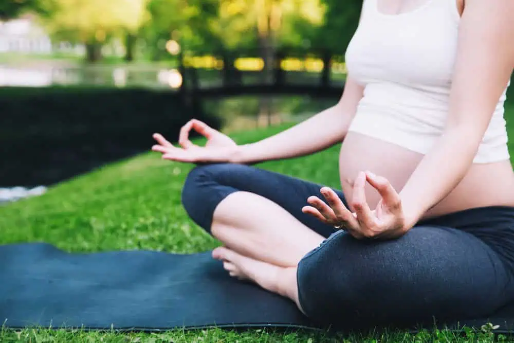 Close-up,Of,Pregnant,Woman,Meditating,While,Sitting,In,Lotus,Position.